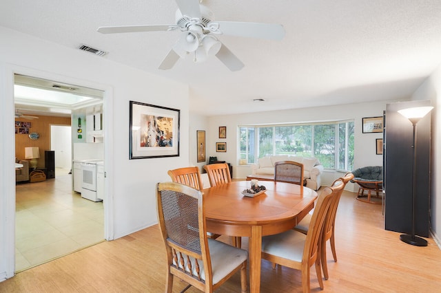 dining area featuring light hardwood / wood-style floors, a textured ceiling, and ceiling fan