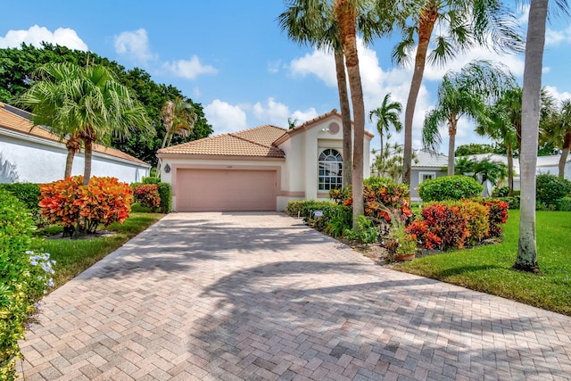 mediterranean / spanish home with a garage and a front lawn