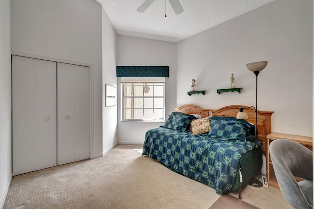 carpeted bedroom with a closet, ceiling fan, and a textured ceiling