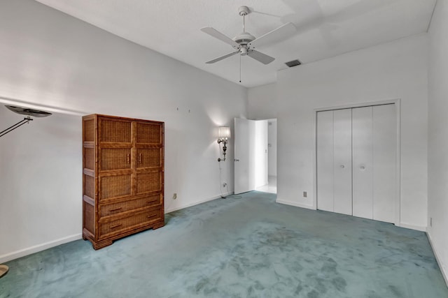 unfurnished bedroom with a closet, carpet, and ceiling fan