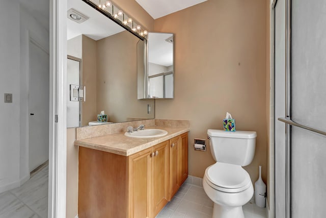 bathroom with vanity, toilet, tile patterned floors, and a shower with shower door