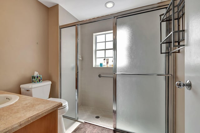 bathroom featuring toilet, tile patterned flooring, vanity, and a shower with door