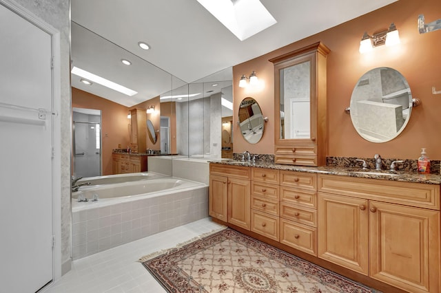 bathroom featuring vanity, lofted ceiling with skylight, plus walk in shower, and tile patterned floors