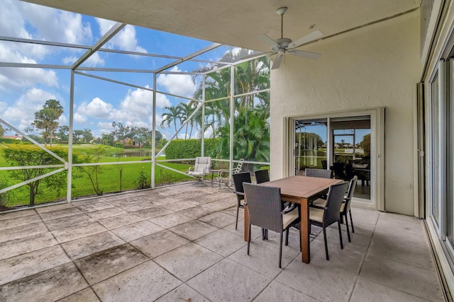 view of patio with ceiling fan and glass enclosure