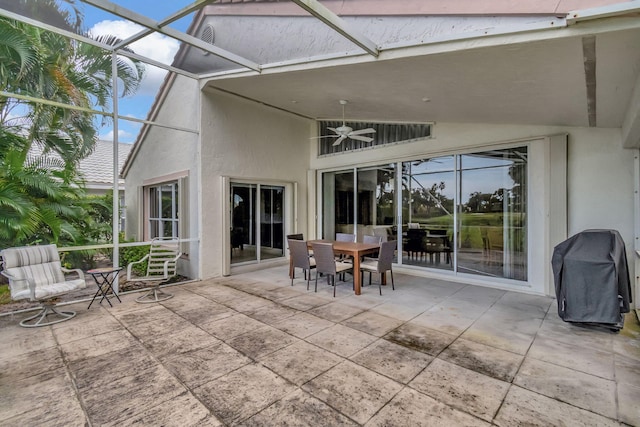 view of patio featuring a grill, glass enclosure, and ceiling fan