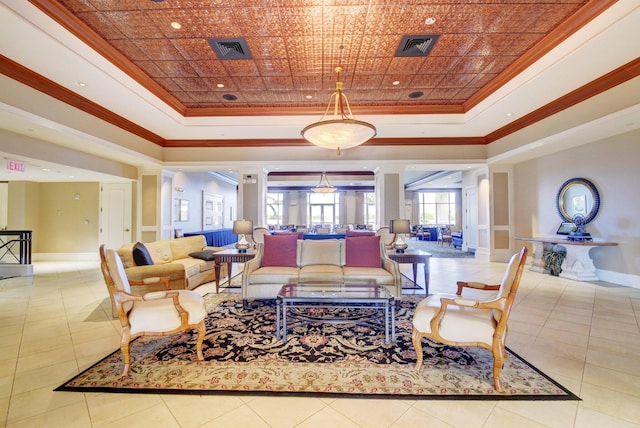 living room with decorative columns, a raised ceiling, and ornamental molding