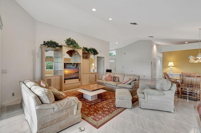 living room featuring a chandelier, vaulted ceiling, and light tile patterned flooring