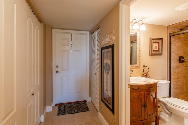 bathroom with toilet, vanity, tile patterned floors, and walk in shower