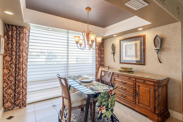 dining room with a raised ceiling, light tile patterned floors, and a notable chandelier