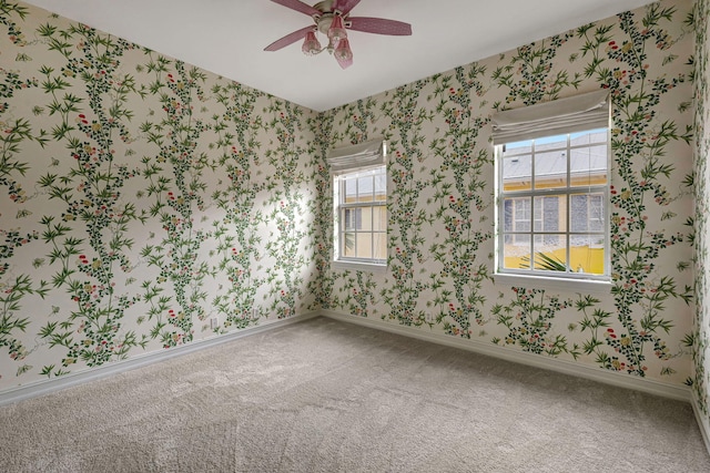 carpeted empty room with plenty of natural light and ceiling fan