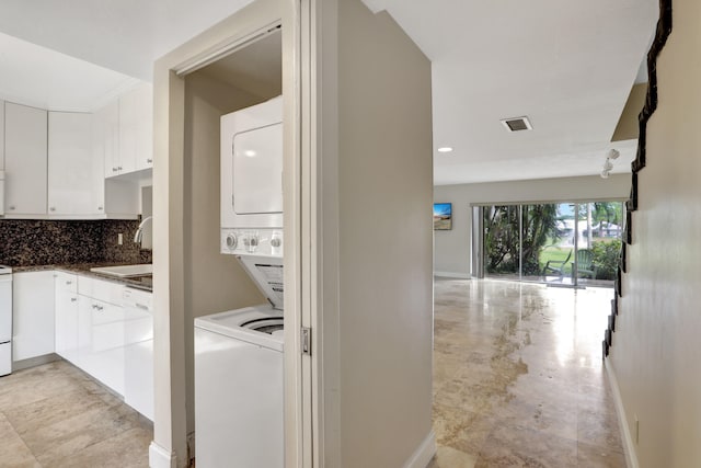 laundry room with stacked washer / dryer and sink