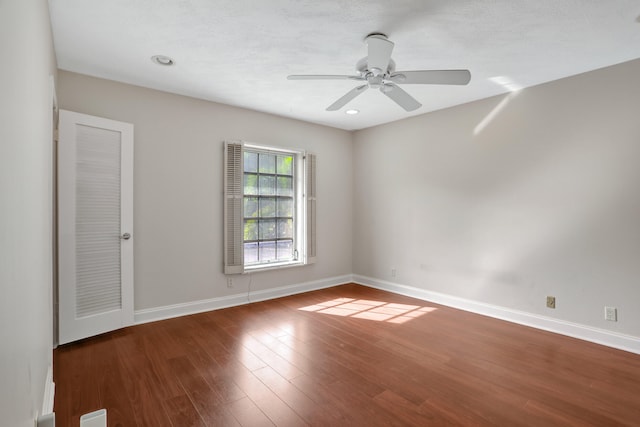 spare room with ceiling fan and dark wood-type flooring