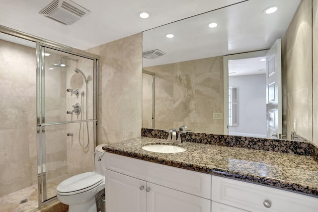 bathroom featuring vanity, tile walls, toilet, and an enclosed shower