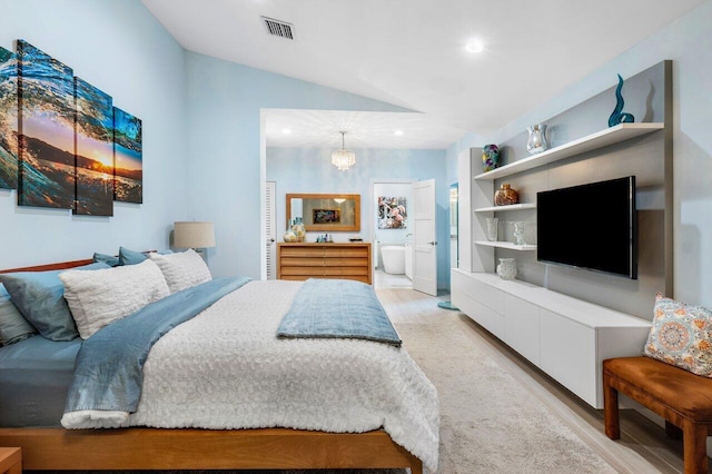 bedroom featuring lofted ceiling, a chandelier, ensuite bathroom, and light hardwood / wood-style floors