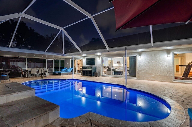 view of swimming pool with a patio area and a lanai