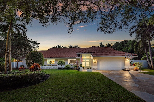 view of front of home with a yard and a garage