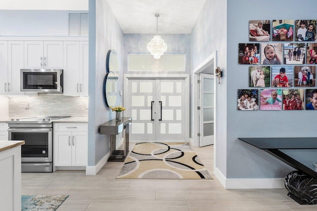 entrance foyer with light hardwood / wood-style floors and a chandelier