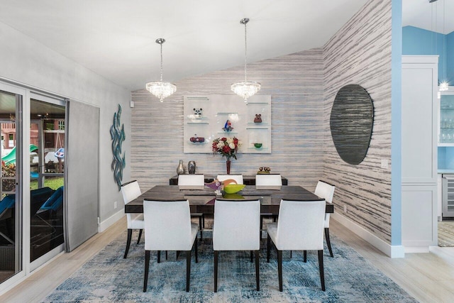 dining room featuring a notable chandelier, wine cooler, light wood-type flooring, and vaulted ceiling