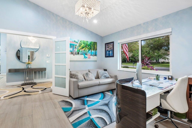 home office featuring light hardwood / wood-style flooring, a notable chandelier, and vaulted ceiling