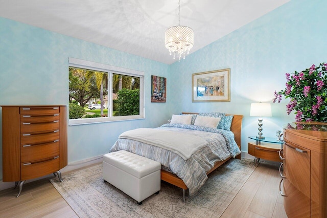 bedroom with a notable chandelier and light hardwood / wood-style floors