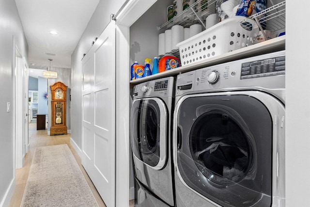 laundry room with light hardwood / wood-style flooring and washer and dryer