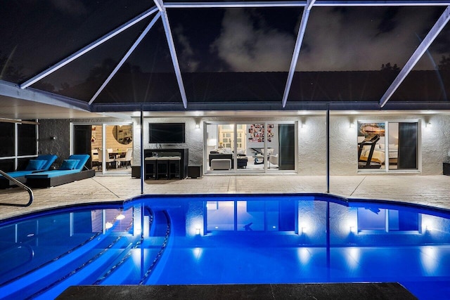 view of swimming pool featuring a patio area and glass enclosure