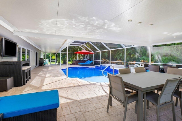 view of pool with area for grilling, a patio area, and a lanai