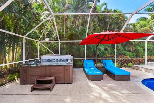 view of patio / terrace with a hot tub and a lanai