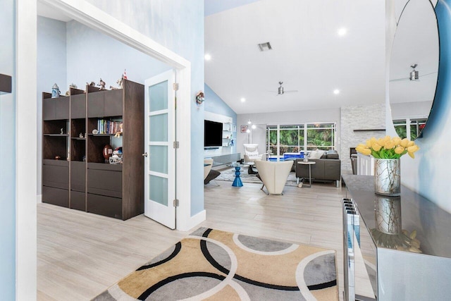 interior space with light hardwood / wood-style floors and high vaulted ceiling