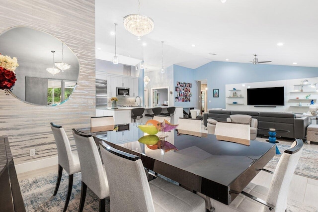 dining room featuring lofted ceiling, a chandelier, and light wood-type flooring