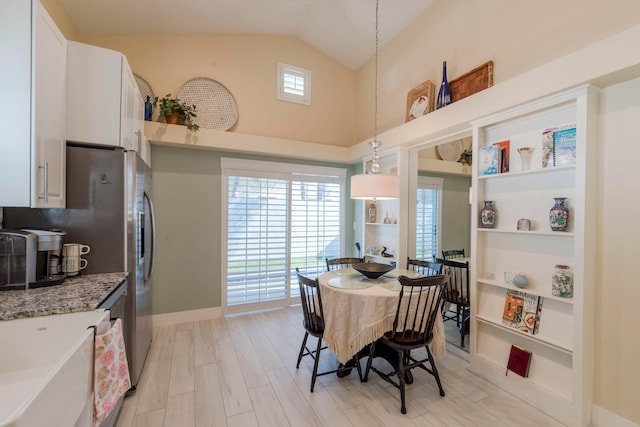 dining room featuring light hardwood / wood-style floors and vaulted ceiling