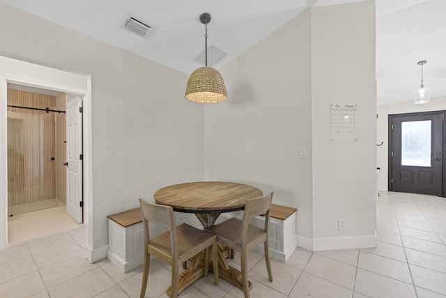 dining area featuring light tile patterned flooring and vaulted ceiling