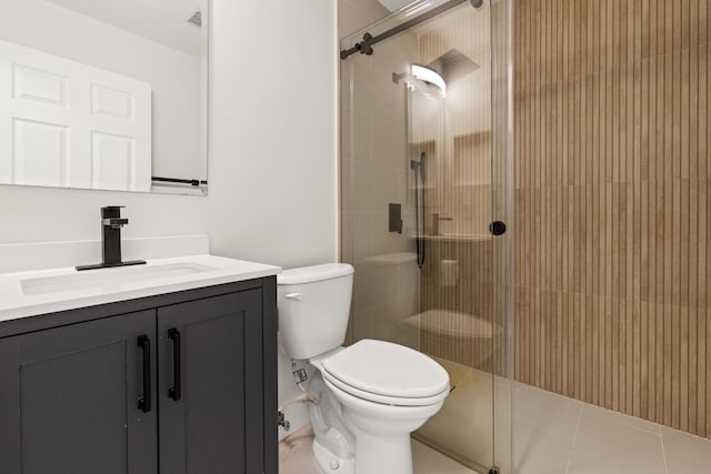 bathroom with toilet, tile patterned flooring, vanity, and a shower with door