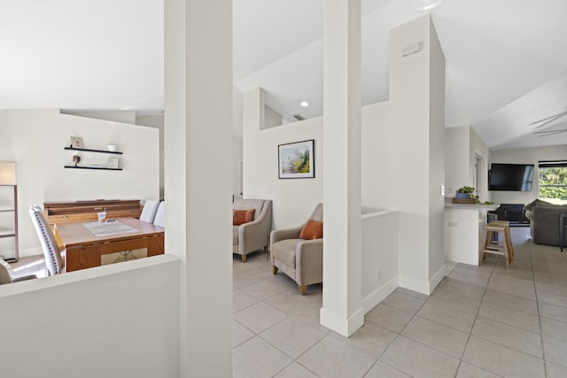 hall with vaulted ceiling and light tile patterned floors