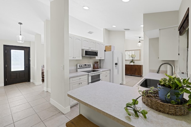 kitchen with hanging light fixtures, sink, vaulted ceiling, white cabinetry, and appliances with stainless steel finishes