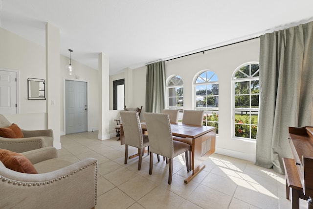 tiled dining space featuring lofted ceiling