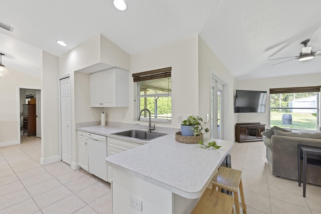 kitchen featuring lofted ceiling, dishwasher, white cabinets, and sink