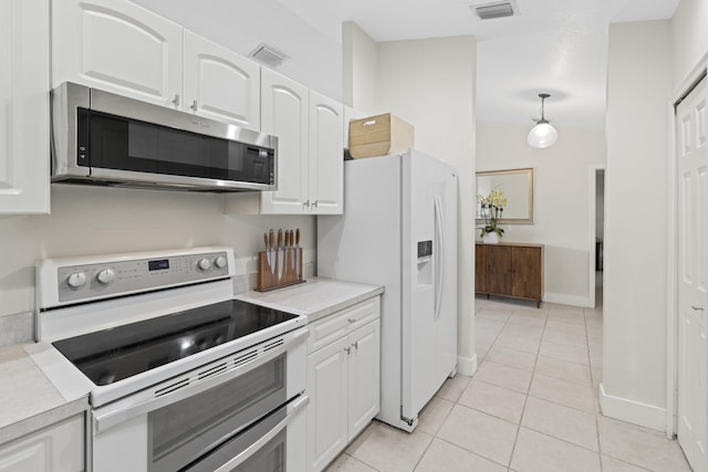 kitchen featuring white cabinetry, stainless steel appliances, vaulted ceiling, decorative light fixtures, and light tile patterned floors