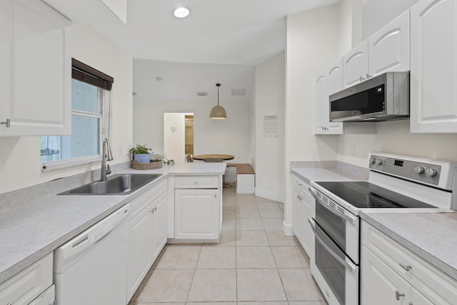 kitchen featuring hanging light fixtures, appliances with stainless steel finishes, white cabinetry, light tile patterned flooring, and sink