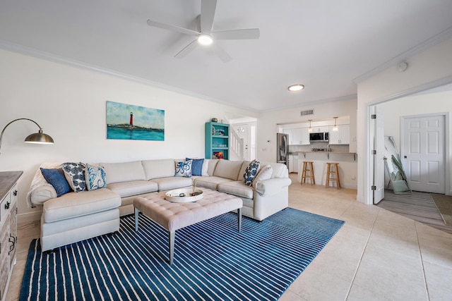 tiled living room featuring ceiling fan and ornamental molding