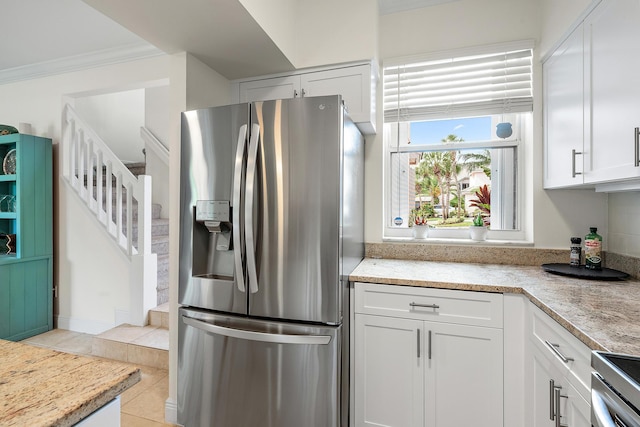 kitchen with white cabinets, stainless steel appliances, and light tile patterned floors