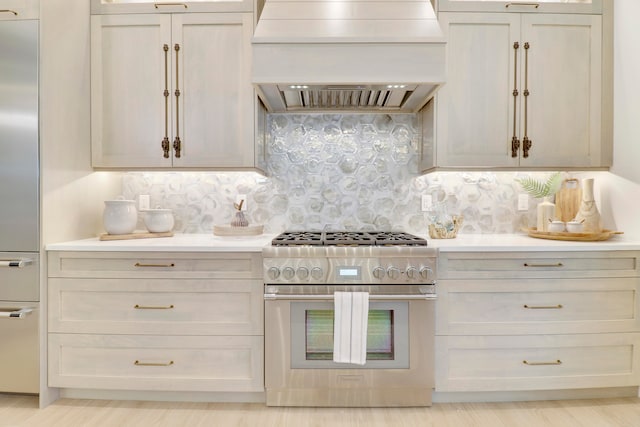 kitchen with light hardwood / wood-style flooring, premium appliances, custom exhaust hood, and tasteful backsplash