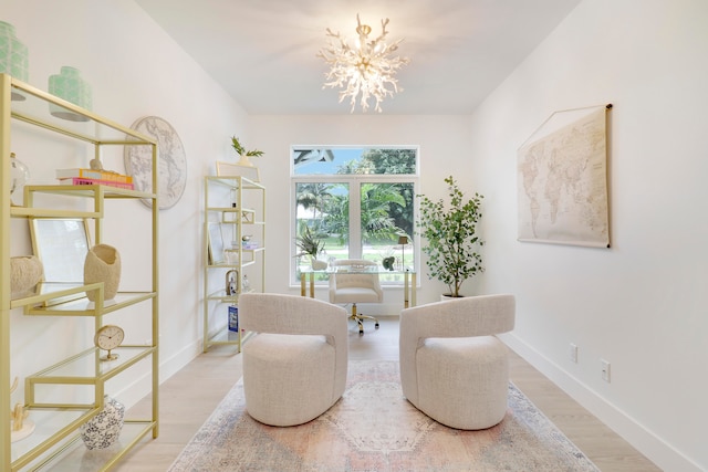 living area with wood-type flooring and an inviting chandelier