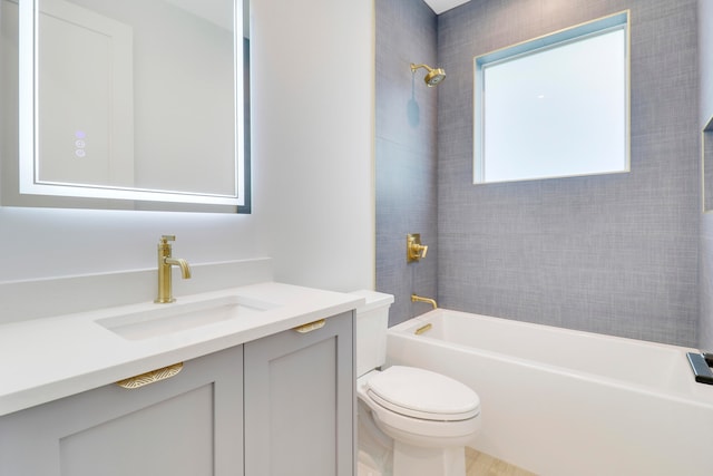 full bathroom featuring tiled shower / bath, vanity, and toilet