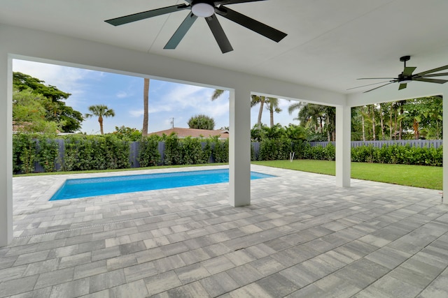 view of swimming pool with ceiling fan, a yard, and a patio