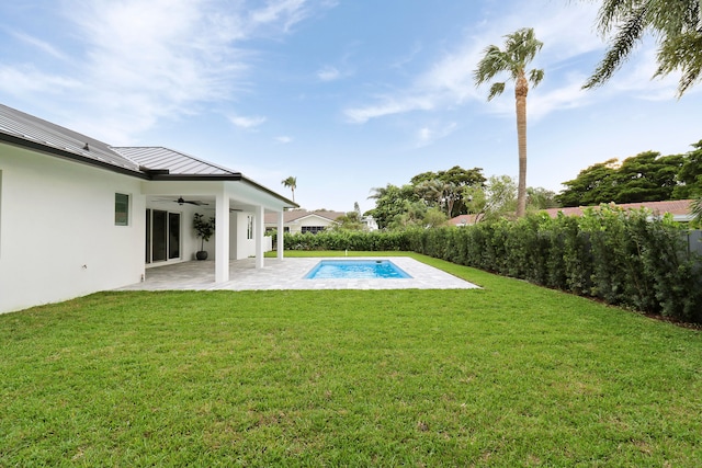 exterior space with ceiling fan, a yard, and a patio area