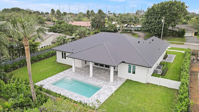 back of house featuring a fenced in pool, a patio, and a lawn