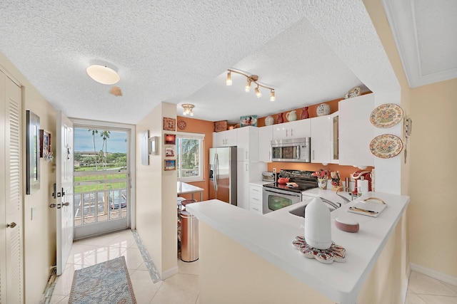 kitchen with kitchen peninsula, white cabinetry, light tile patterned flooring, and appliances with stainless steel finishes