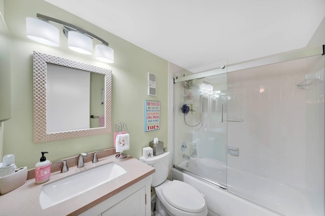 full bathroom featuring vanity, bath / shower combo with glass door, and toilet