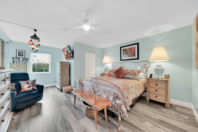 bedroom featuring ceiling fan, a closet, a textured ceiling, and light wood-type flooring